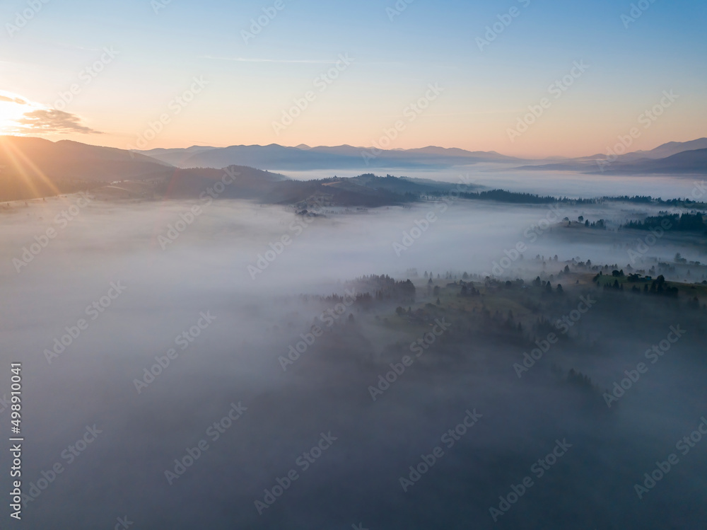 Flight over fog in Ukrainian Carpathians in summer. Mountains on the horizon. Aerial drone view. Flight over fog in Ukrainian Carpathians in summer. Mountains on the horizon. Aerial drone view.