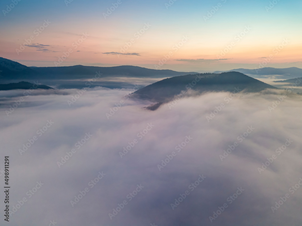 The rays of dawn over the fog in the Ukrainian Carpathians. Aerial drone view. The rays of dawn over the fog in the Ukrainian Carpathians. Aerial drone view.