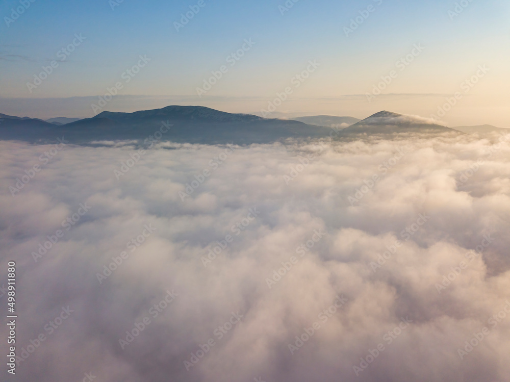 Flight over fog in Ukrainian Carpathians in summer. Mountains on the horizon. Aerial drone view. Flight over fog in Ukrainian Carpathians in summer. Mountains on the horizon. Aerial drone view.
