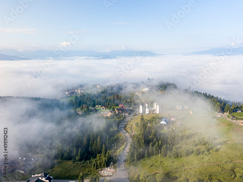 Mountain settlement in the Ukrainian Carpathians in the morning mist. Aerial drone view. © Sergey