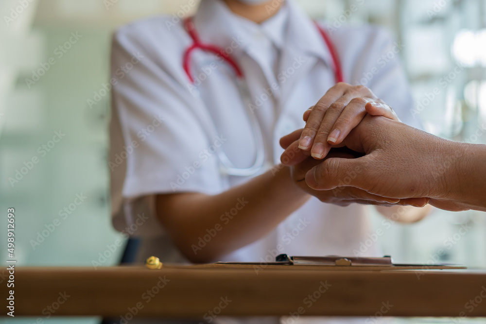 Obraz premium The doctor shook the patient's hand to offer advice and encouragement at the table. or describe the abnormalities of the patient's body in the hospital