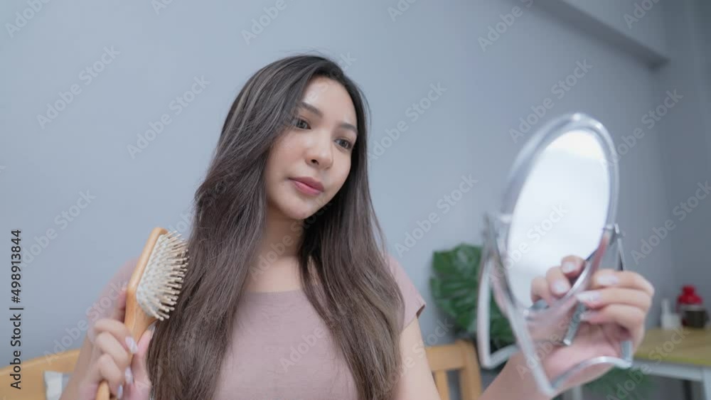 Holiday concept of 4k Resolution. Young Asian woman combing her hair in the bedroom. Holiday concept of 4k Resolution. Young Asian woman combing her hair in the bedroom.