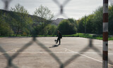 BOY IN BLACK TRACKSUIT FREESTYLE WITH A BALL ON A FUTSAL FIELD