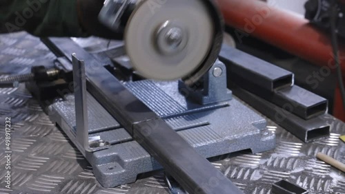 Locksmith in special clothes and goggles works in production. Metal processing with angle grinder. Sparks in metalworking