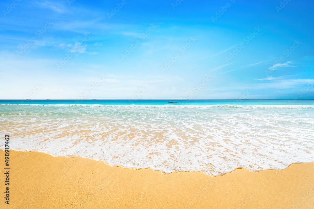 Beautiful natural background image of tropical beach. Blue sky with light clouds, turquoise ocean with rolling surf with white foam and gold sand. Harmony of clean environment.