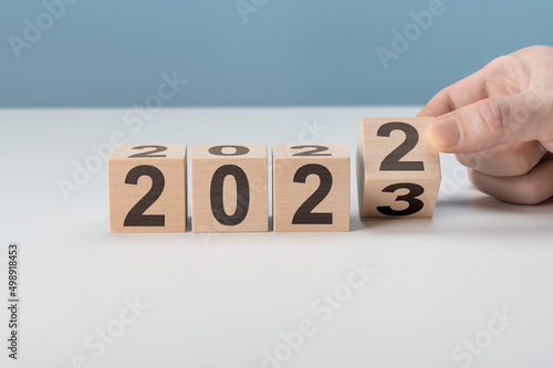 happy 2023 new year concept, Flipping of wooden cube block change from 2022 to 2023. Start new year 2023 with goal plan, goal concept, action plan, strategy, new year business vision.