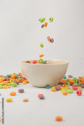 Colorful cereal box for morning breakfast. Corn flakes falling to the white bowl. Motion.