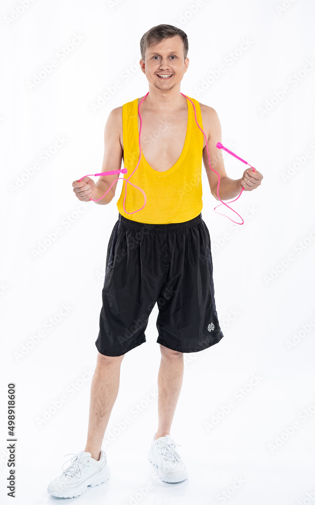 fitness man with a slim body, an athlete in black shorts and a yellow t-shirt with a jump rope. isolated white background
