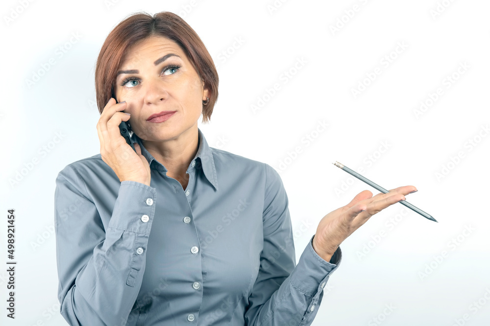 Business beautiful woman speaks on the phone with a pencil in her hand on a white background Business beautiful woman speaks on the phone with a pencil in her hand on a white background