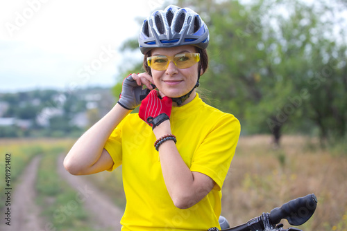 Beautiful woman cyclist with a bicycle on the nature. Healthy lifestyle and sport. Leisure and hobbies
