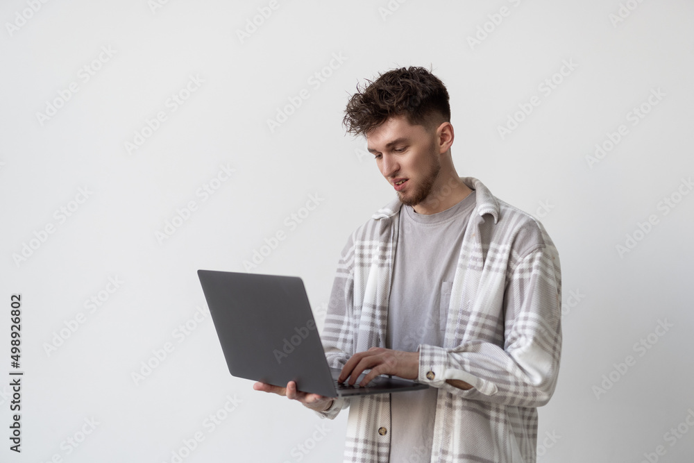 Portrait of a man using laptop computer over gray background Portrait of a man using laptop computer over gray background