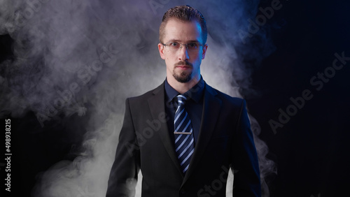 Male businessman on black background with smoke wearing eyesight glasses looking smart