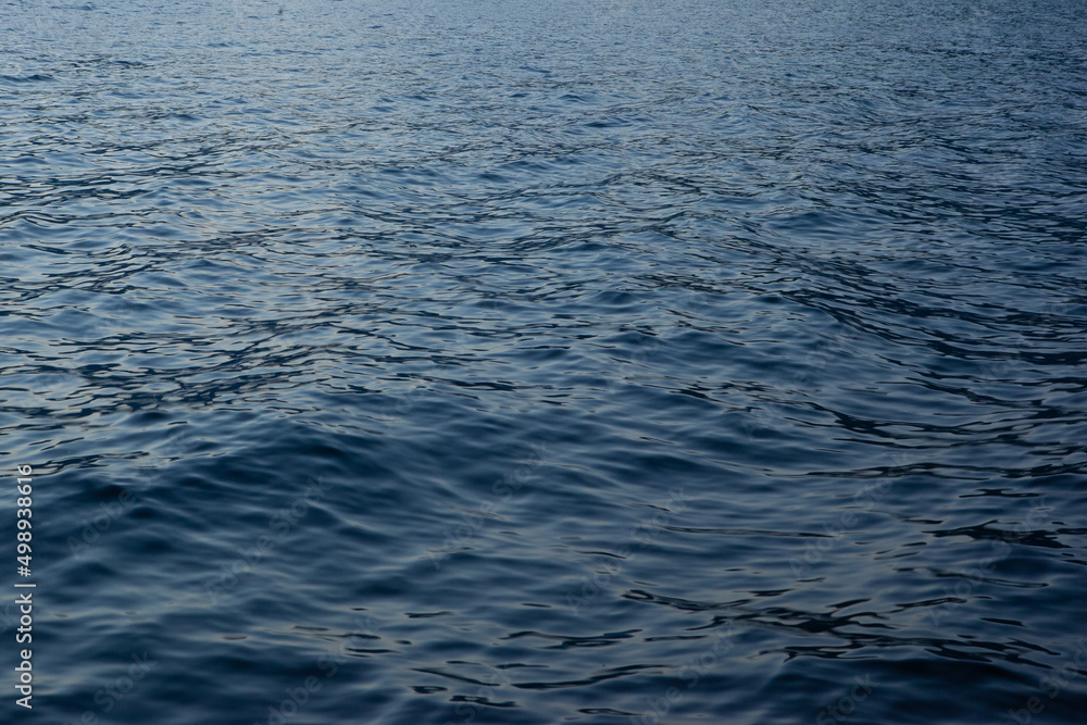 Naklejka premium Blue sea background, close-up. A backing with sea waves texture for branding, calendar, postcard, screensaver, wallpaper, poster, banner, cover, website. A place for your design or text
