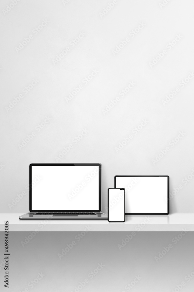 Laptop, mobile phone and digital tablet pc on white concrete wall shelf. Vertical background Laptop, mobile phone and digital tablet pc on white concrete wall shelf. Vertical background