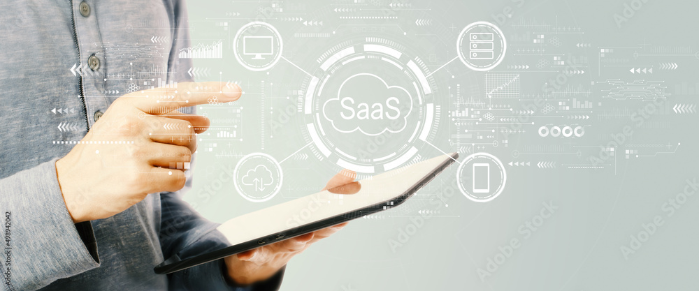 Obraz premium SaaS - software as a service concept with young man holding a tablet computer