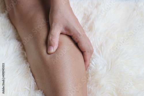 woman suffering from leg pain at home
