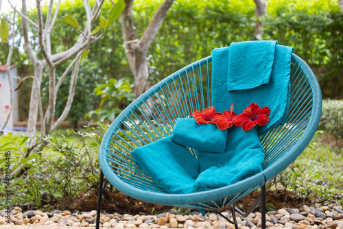 A green towel with flowers is placed on the chair.