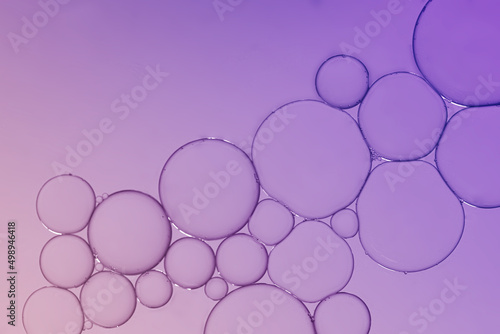 Oil and water bubble on purple gradient background.