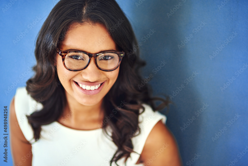 Its all about confidence. Studio portrait of a confident young woman posing against a blue background. Its all about confidence. Studio portrait of a confident young woman posing against a blue background.