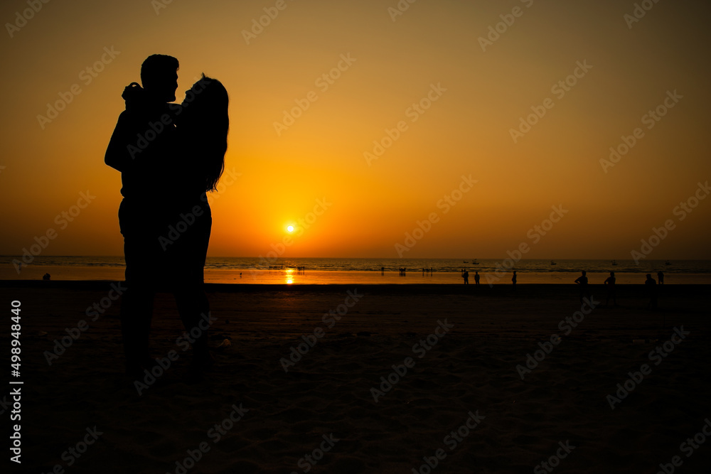 A beautiful silhouette of a couple hugging each other, enjoying intimacy and making love at a beach during sunset. A beautiful silhouette of a couple hugging each other, enjoying intimacy and making love at a beach during sunset.