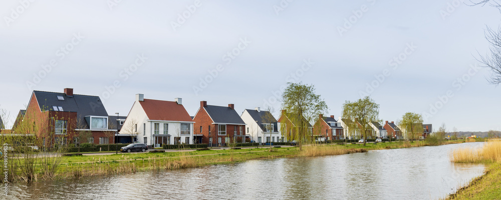 Obraz premium Row of modern newly build family houses along canal in Kortenoord in Wageningen, Gelderland in The Netherlands