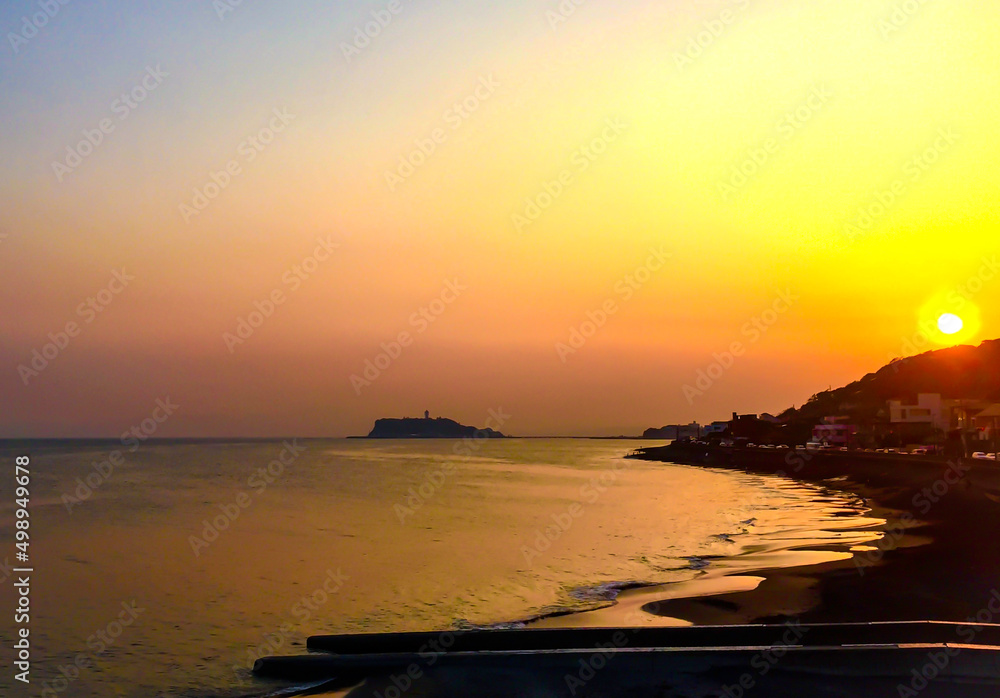 夕日で鮮やかなオレンジに染まる稲村ケ崎と江の島