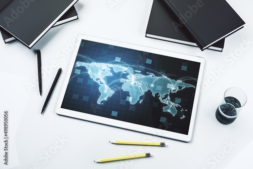 Modern digital tablet display with abstract graphic world map with connections, globalization concept. Top view. 3D Rendering