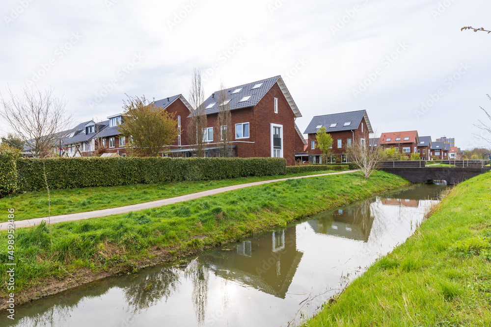 Modern newly build family houses along canal in Kortenoord in Wageningen, Gelderland in The Netherlands Modern newly build family houses along canal in Kortenoord in Wageningen, Gelderland in The Netherlands