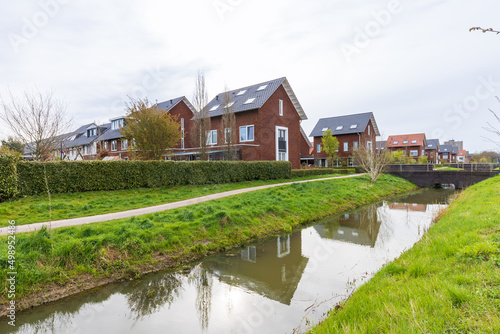 Modern newly build family houses along canal in Kortenoord in Wageningen, Gelderland in The Netherlands