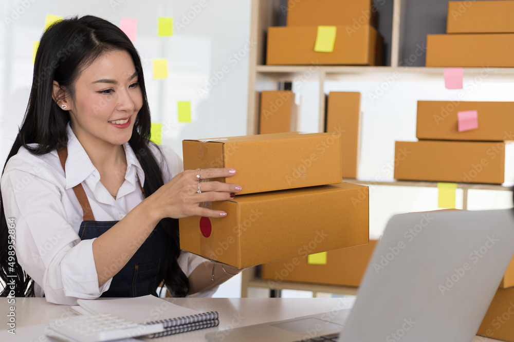 E-commerce startup is working in a home office while preparing parcels for delivery. E-commerce startup is working in a home office while preparing parcels for delivery.