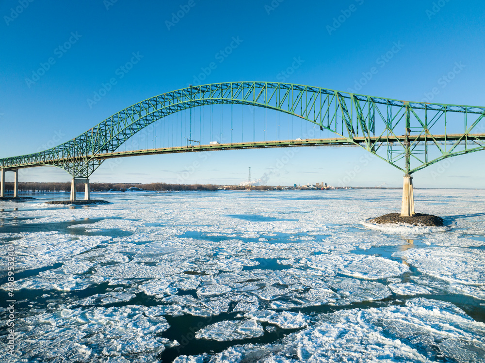 Fototapeta premium Laviolette Bridge, during winter, crossing the St. Lawrence River and ice floe in Trois-Rivieres, Quebec, Canada