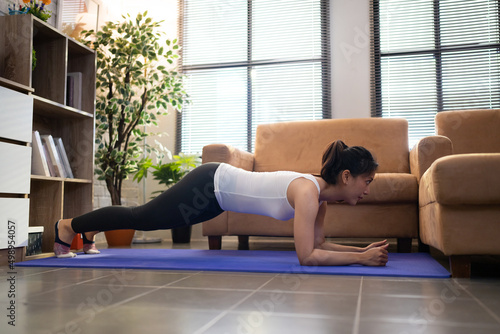 Asian women exercise at home on the sofa she plank