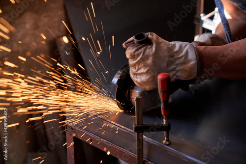 Fotografia, Obraz Crop man doing metalwork with angle grinder