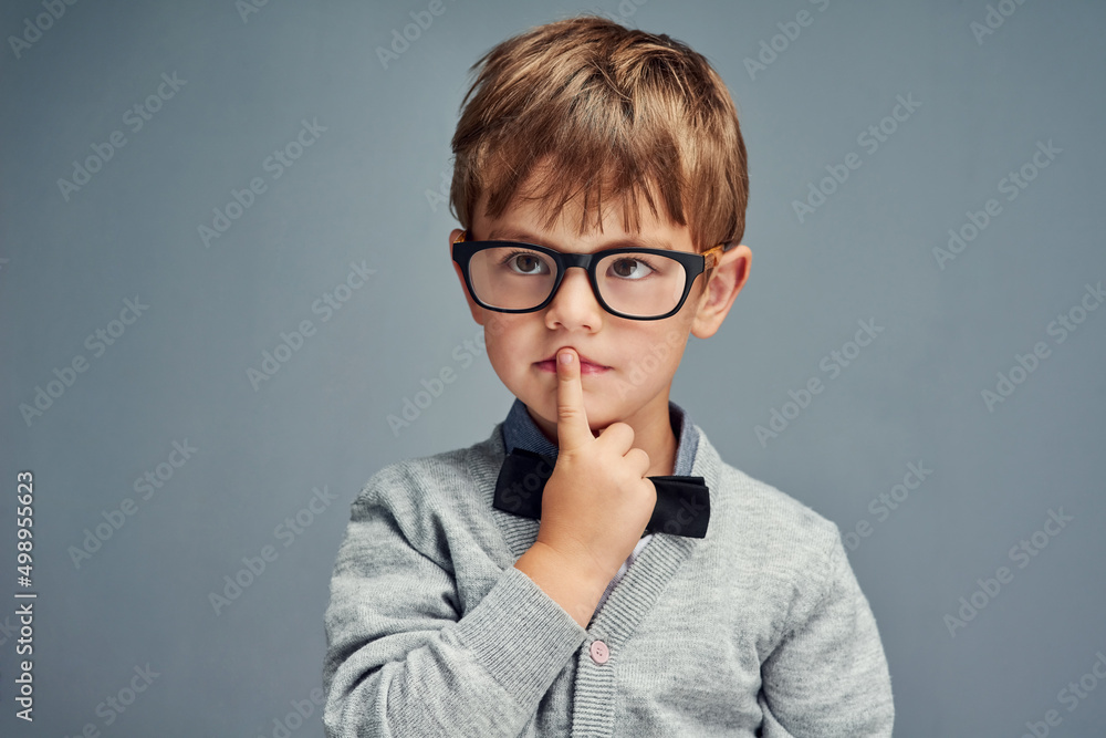 Question everything. Studio shot of a smartly dressed little boy looking thoughtful against a gray background. Question everything. Studio shot of a smartly dressed little boy looking thoughtful against a gray background.