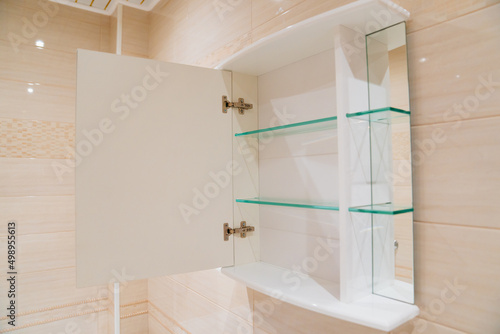 wall cabinet with mirror and shelves for storage in the bathroom.