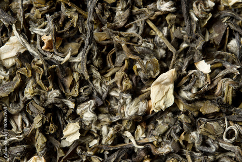 Green tea with jasmine petals on white background. Top view. Close up. High resolution