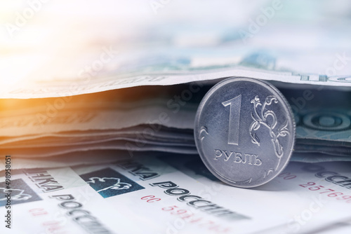 Russian ruble coin on the background of paper banknotes of 1000 rubles. photo