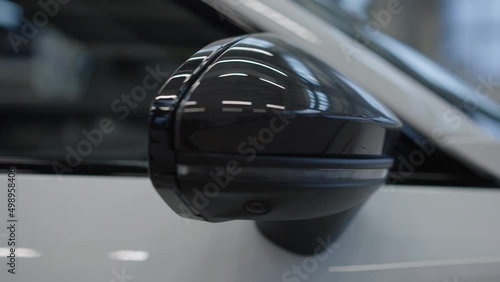 Lights reflecting on black side mirror of modern car, rack focus. photo