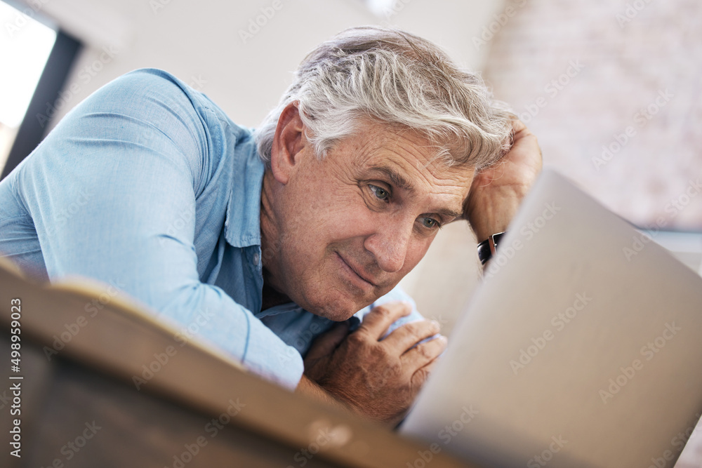 I can barely watch. Shot of a mature man sitting alone and feeling stressed while using his laptop to work from home. I can barely watch. Shot of a mature man sitting alone and feeling stressed while using his laptop to work from home.