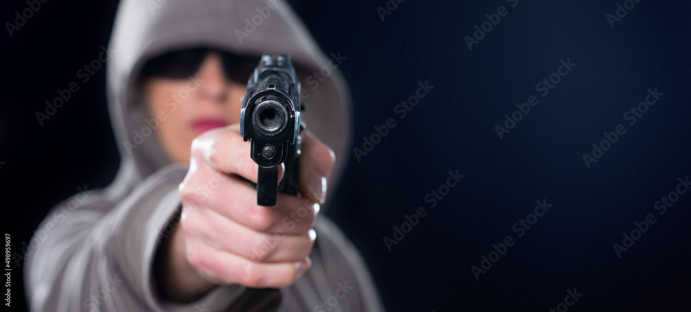 Young woman shooting with gun isolated on black background Young woman shooting with gun isolated on black background