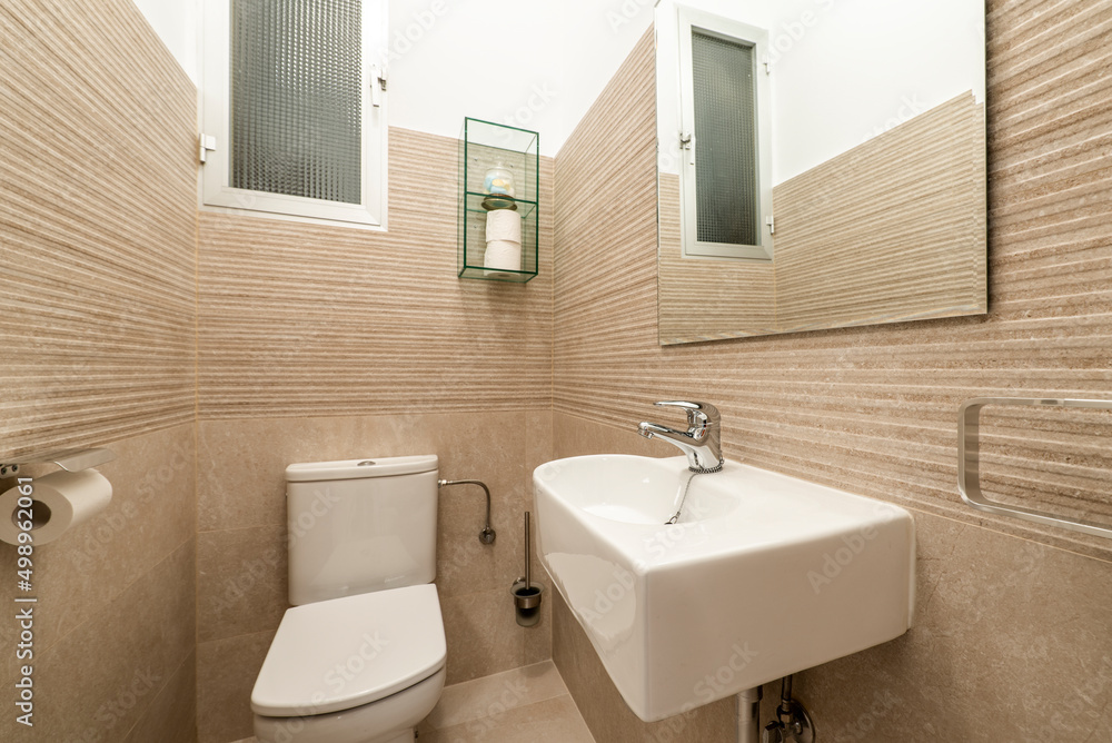Small cloakroom with white porcelain sink, frameless mirror, and cream tile Small cloakroom with white porcelain sink, frameless mirror, and cream tile