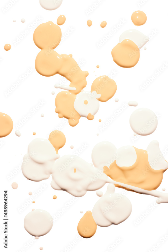 Light beige liquid tone foundation drops on white