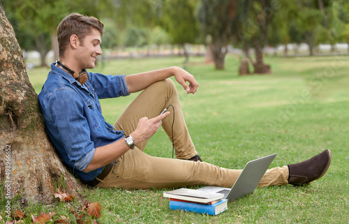 Better than any library. Shot of a handsome young man studying in the park with a laptop. © Tylan E/peopleimages.com