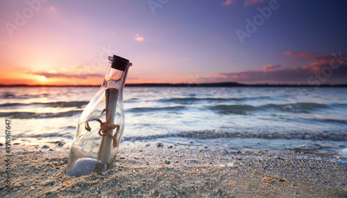 romantic sunset at the beach with bottle with a message photo
