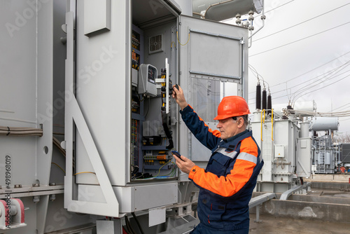 Electrical engineer inspecting switch cabinets in high voltage substations