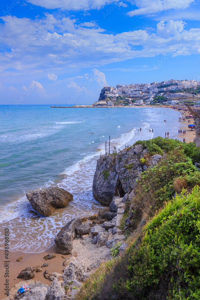Bay of Peschici in Apulia, Italy: view of townscape and sandy beach. Peschici is famous town for its seaside resorts, its territory belongs to the Gargano National Park.