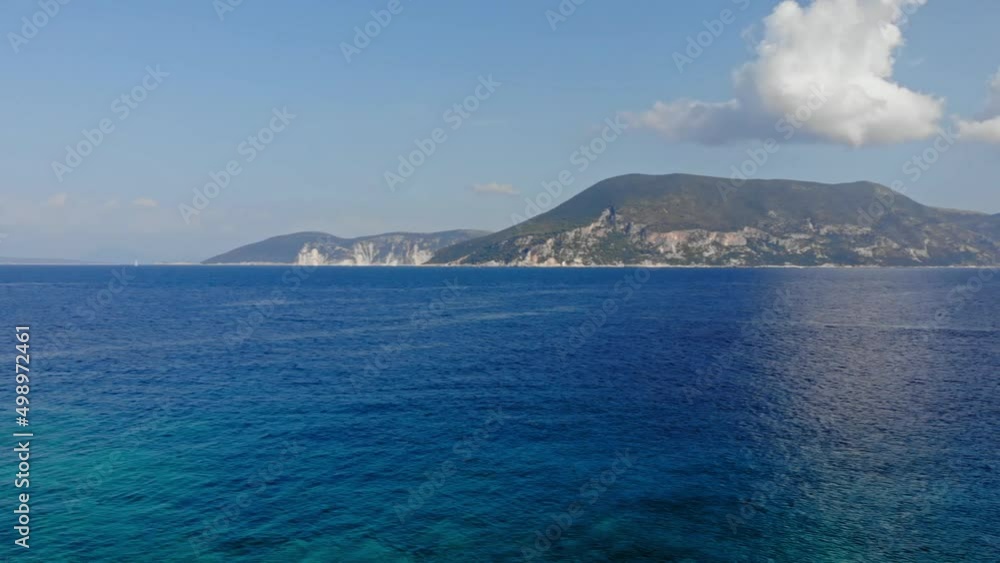 Scenic Rocky Shoreline And Blue Waters of Paralia Emplisi, Kefalonia Being Sailed By Boats In Greece With Mountain Slopes Seen On The Background- Pan Shot Scenic Rocky Shoreline And Blue Waters of Paralia Emplisi, Kefalonia Being Sailed By Boats In Greece With Mountain Slopes Seen On The Background- Pan Shot