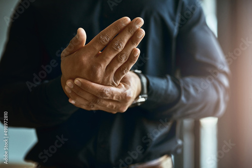 Feeling numbness and pain in his hands. Closeup shot of an unidentifiable businessman suffering with pain in his hands. © Jadon Bester/peopleimages.com