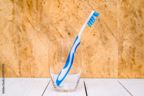 Toothbrush stands in a glass on a beige background 