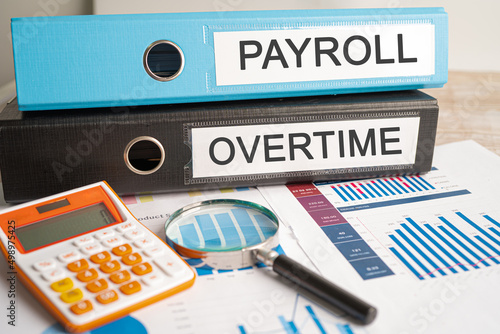 Payroll and Overtime. Binder data finance report business with graph analysis in office. photo